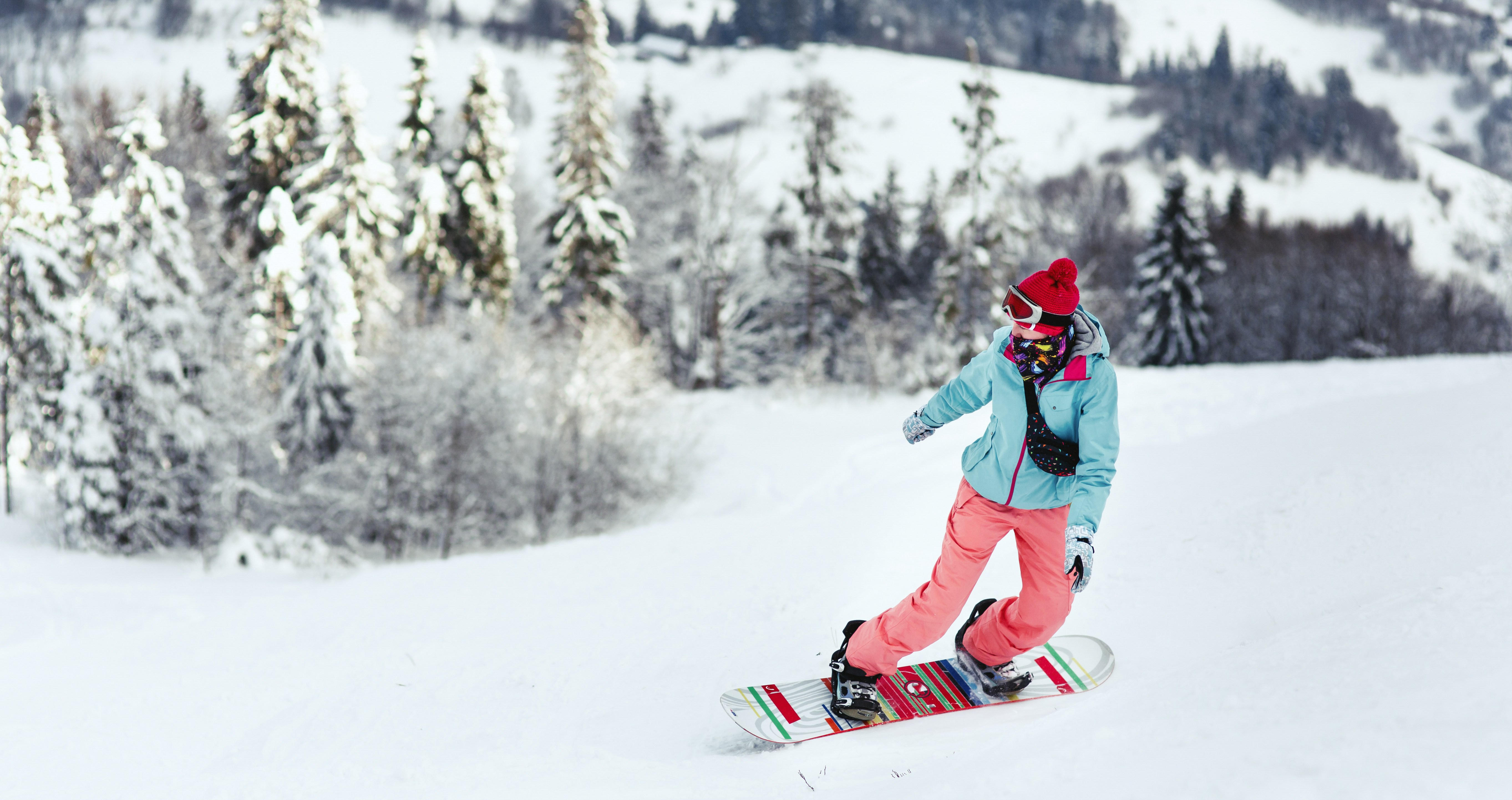 Woman in ski suit looks over her shoulder going down the hill on
