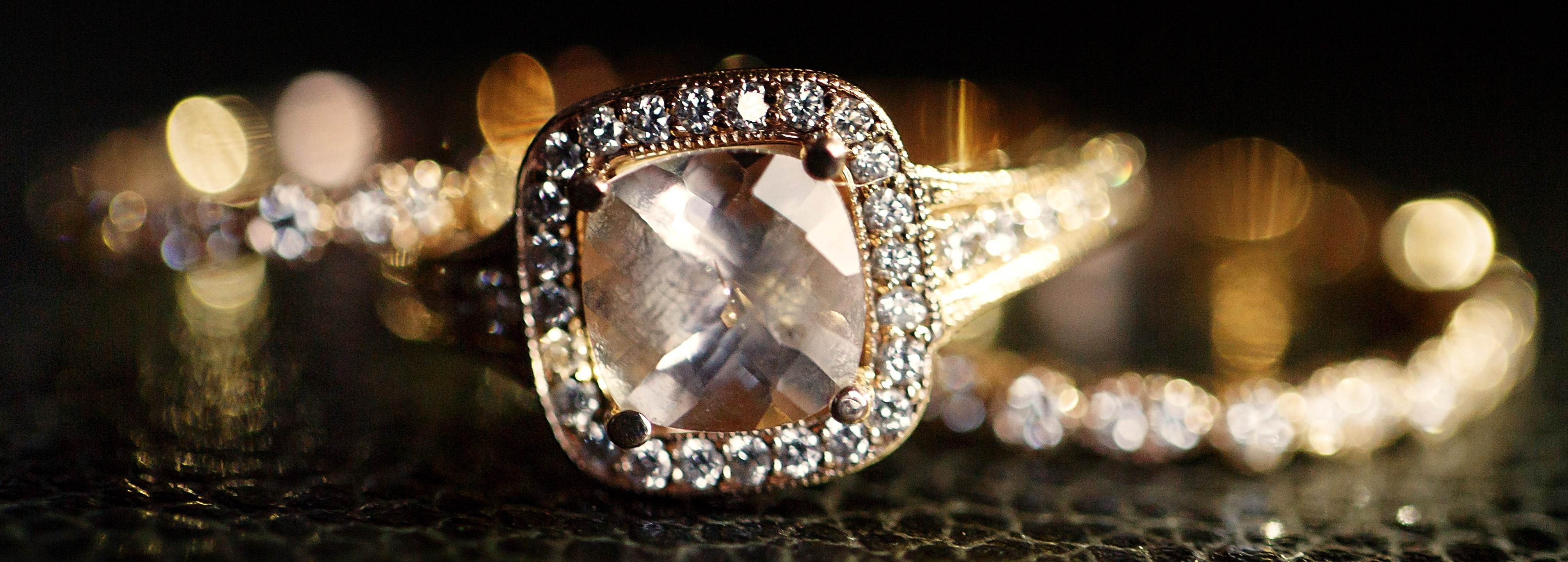 Jewels sparkle in the golden wedding rings lying on the leather